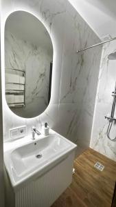 a white bathroom with a sink and a mirror at Yu-home 2 in Mukacheve