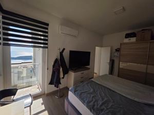 a bedroom with a bed and a television and a window at Exclusive penthouse with stunning panoramic views in Prijevor
