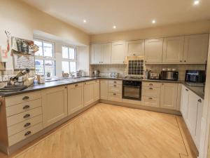 a large kitchen with white cabinets and a wooden floor at Old Bridge Inn in Carnforth