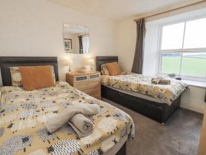 a bedroom with two beds and a window at Old Bridge Inn in Carnforth