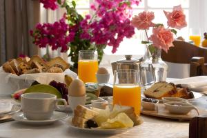a table with a breakfast of bread and eggs and orange juice at Doukissa Hotel - Parikia Town Centre in Parikia