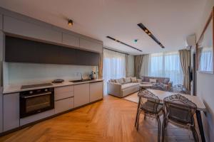 a kitchen and living room with a table and chairs at Moon Shine Apart in Altınkum