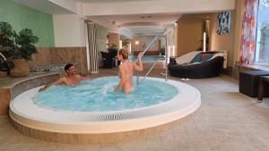 a man and a girl in a hot tub at Göbel`s Hotel Quellenhof in Bad Wildungen