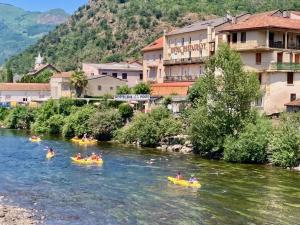 a group of people kayaking down a river in a town at Logis Hôtel Restaurant de la Poste in Tarascon-sur-Ariège