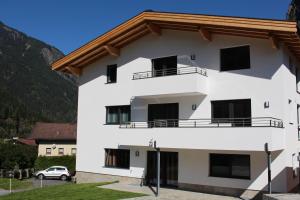 a white building with a brown roof at Alps 3000-2 in Umhausen