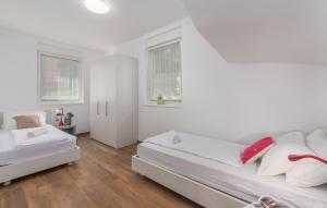 a white bedroom with two beds and two windows at VILA PALISKA in Pula +8 photos