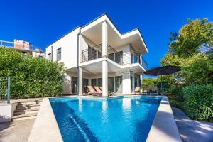 a house with a swimming pool in front of a house at VILA PALISKA in Pula