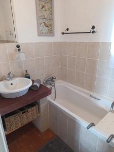 a bathroom with a bath tub and a sink at Uitkyk Guest House in Fouriesburg