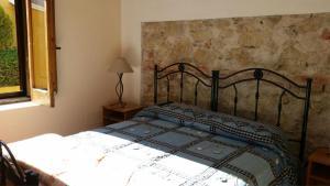 a bedroom with a bed with a iron headboard and a window at Agriturismo La Pigna in Corigliano Calabro