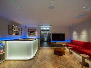 a living room with a red couch and a bar at Section L Akihabara in Tokyo