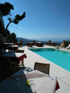 - une piscine avec une table et des chaises à côté dans l'établissement Agriturismo La Pigna, à Corigliano Calabro
