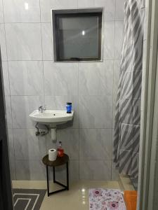 a bathroom with a sink and a mirror at Namhla Guest House in Nongoma