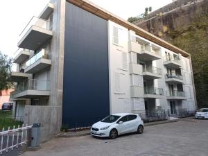 a white car parked in front of a building at Costa Lodge, private room in Santa Cruz