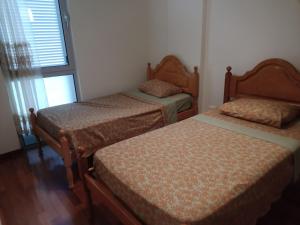 a bedroom with two beds and a window at Costa Lodge, private room in Santa Cruz
