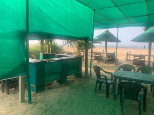 a table and chairs on the beach under an umbrella at Arabian Breeze in Tadri