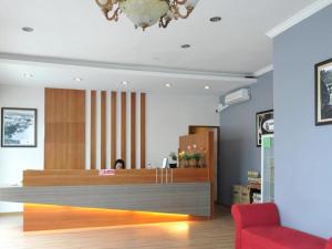 a lobby with a reception desk and a red chair at Point Stay BDC Airport in Kuching