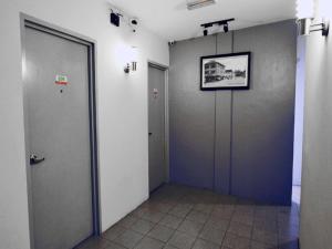 a hallway with two doors and a picture on the wall at Point Stay BDC Airport in Kuching