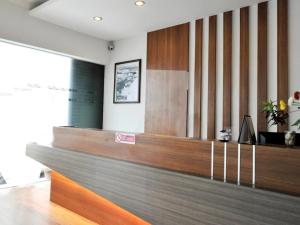 a reception desk in a lobby with a sign on it at Point Stay BDC Airport in Kuching +9 photos