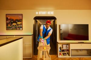 a man is standing in a kitchen with a stool at Section L Akihabara in Tokyo