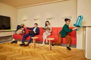 a group of people sitting on a couch in a room at Section L Akihabara in Tokyo