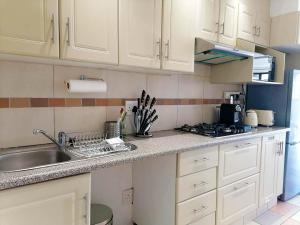 a kitchen with white cabinets and a sink at Crayfish Inn No.4 in Ramsgate