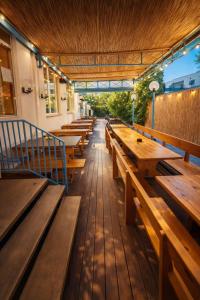 a row of wooden benches sitting inside of a restaurant at Sunflower Beach Backpacker Hostel & Bar in Rimini +95 photos