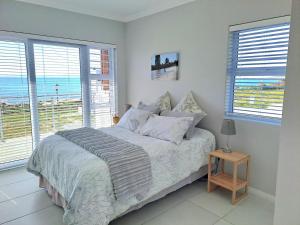 a bedroom with a bed with a view of the ocean at West Coast Rock in St. Helena Bay