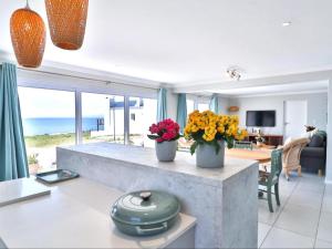 a living room with two vases of flowers on a counter at West Coast Rock in St. Helena Bay