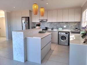 a kitchen with white cabinets and a washer and dryer at West Coast Rock in St. Helena Bay