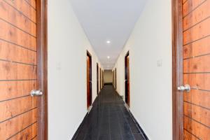 a corridor of corridors in a house with wooden doors at Hotel O RB STAY in Haidar Sāhibgūda