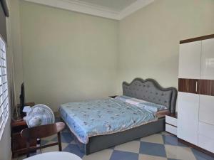 a bedroom with a bed with a fan and a chair at TH Homestay in Danang