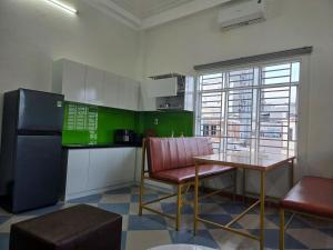 a kitchen with a table and chairs and a refrigerator at TH Homestay in Danang +5 photos