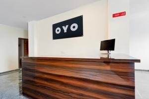 a reception desk in a room with a sign on a wall at Hotel O RB STAY in Haidar Sāhibgūda