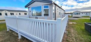 a white fence with a large window on a house at S & S Retreat in Heysham