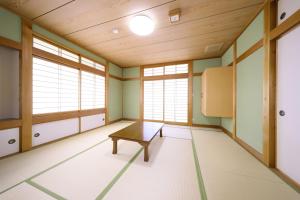 an empty room with a table and windows at 旧GATE80香住 無人宿 完全セルフ 予約メッセージ欄確認要す スマートロック 暗証番号チェックイン 素泊まり専門 アメニティ持参で格安滞在 セコム24h監視 駐車場10台 in Kami +25 photos
