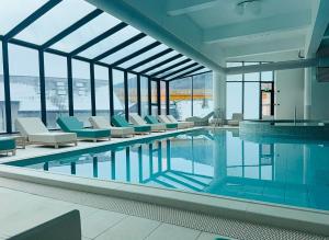 a pool in a building with chairs and a swimming pool at Home & Garden with stunning view in Sinaia
