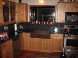 una cocina con armarios de madera y fregadero en Alta Peak Vista en Three Rivers