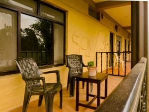 two chairs and a table on a balcony at Babai Outback Adventures PVT LTD in Bardiyā