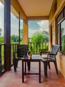 two chairs and a coffee table on a porch at Babai Outback Adventures PVT LTD in Bardiyā