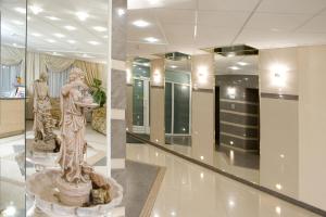 a lobby with a statue of a woman at Paradise Hotel in Gomel