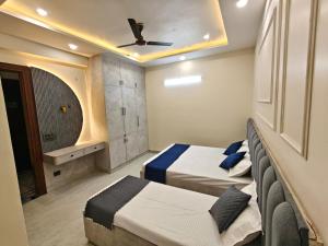 a bedroom with two beds and a ceiling fan at Pg walaah suites in Noida