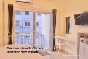 a room with a door open to a balcony at Thai Orchid Guest House in Jomtien Beach