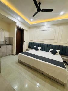 a bedroom with a large bed with a ceiling fan at Pg walaah suites in Noida