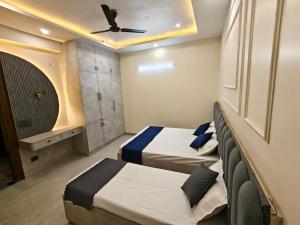 a bedroom with two beds and a ceiling at Pg walaah suites in Noida