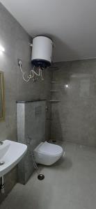 a bathroom with a sink and a toilet and a light at Ganga Aura in Gurgaon