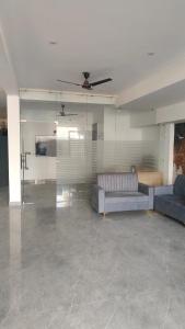 a living room with a couch and a ceiling fan at Ganga Aura in Gurgaon