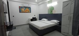 a bedroom with a bed and a painting on the wall at Ganga Aura in Gurgaon