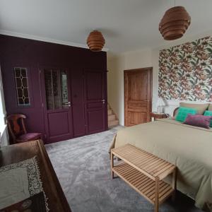 a bedroom with a large bed and purple doors at Les chambres du Lohan in Daoulas