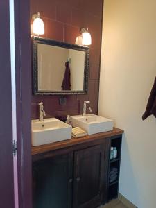 a bathroom with two sinks and a mirror at Les chambres du Lohan in Daoulas