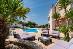 a patio with lounge chairs and a swimming pool at Villa Milina Korčula in Vela Luka +39 photos